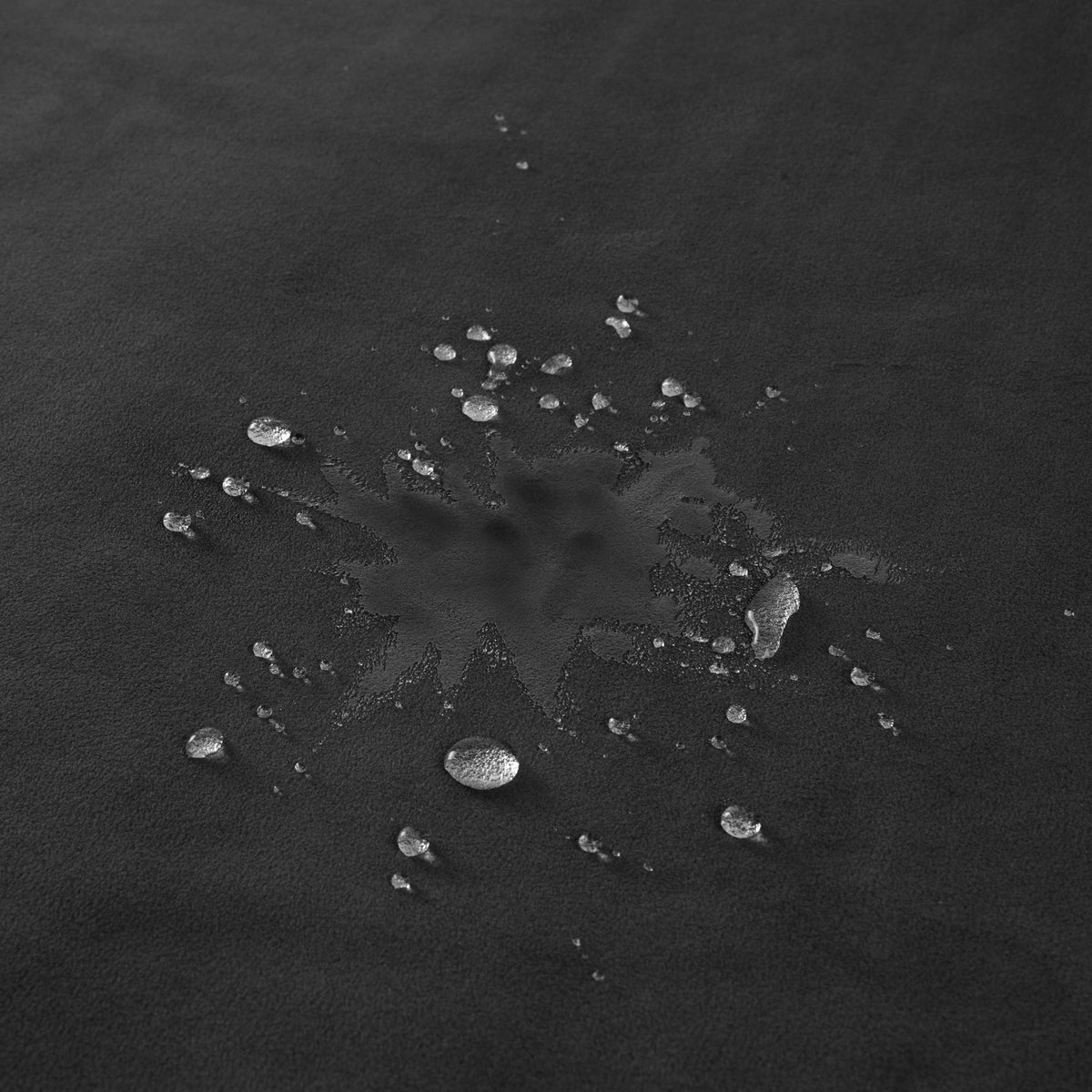 Water droplets beading on the surface of the black Fascinator Mini, close-up