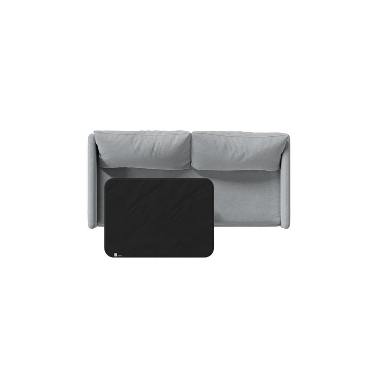 Black Fascinator Mini on a grey sofa, seen from above to show its size