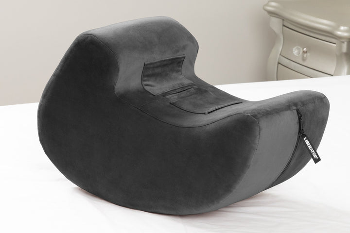 Black Pulse cushion sitting on a white bed in a bedroom