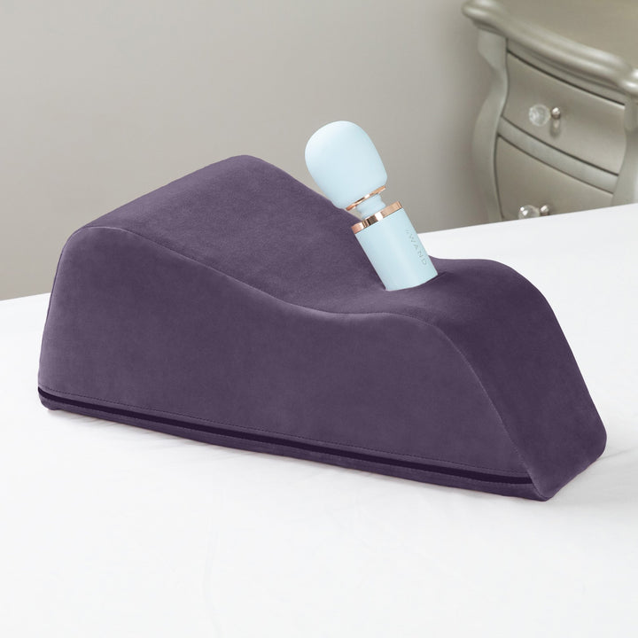 Purple Wanda cushion with a pale blue wand in place, on a white bed