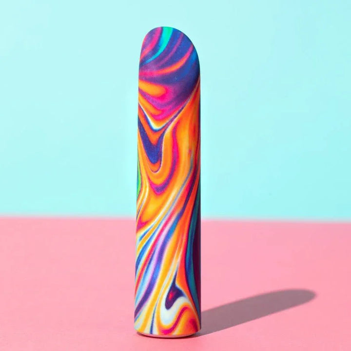Rainbow marbled Psyche bullet standing upright against pink and mint blocks