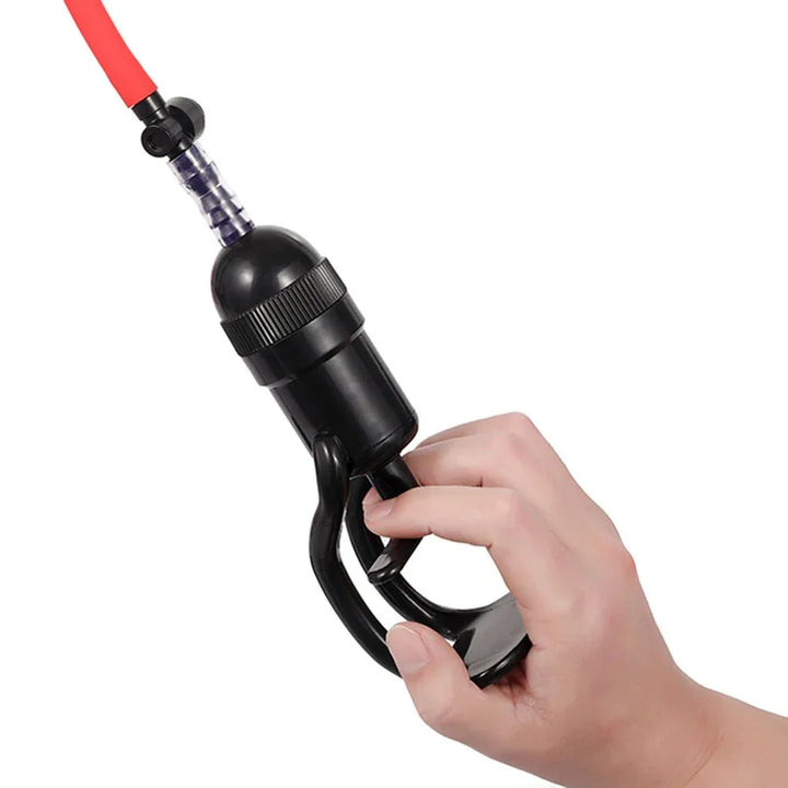 Vagina pump handle held in a hand, red hose attached