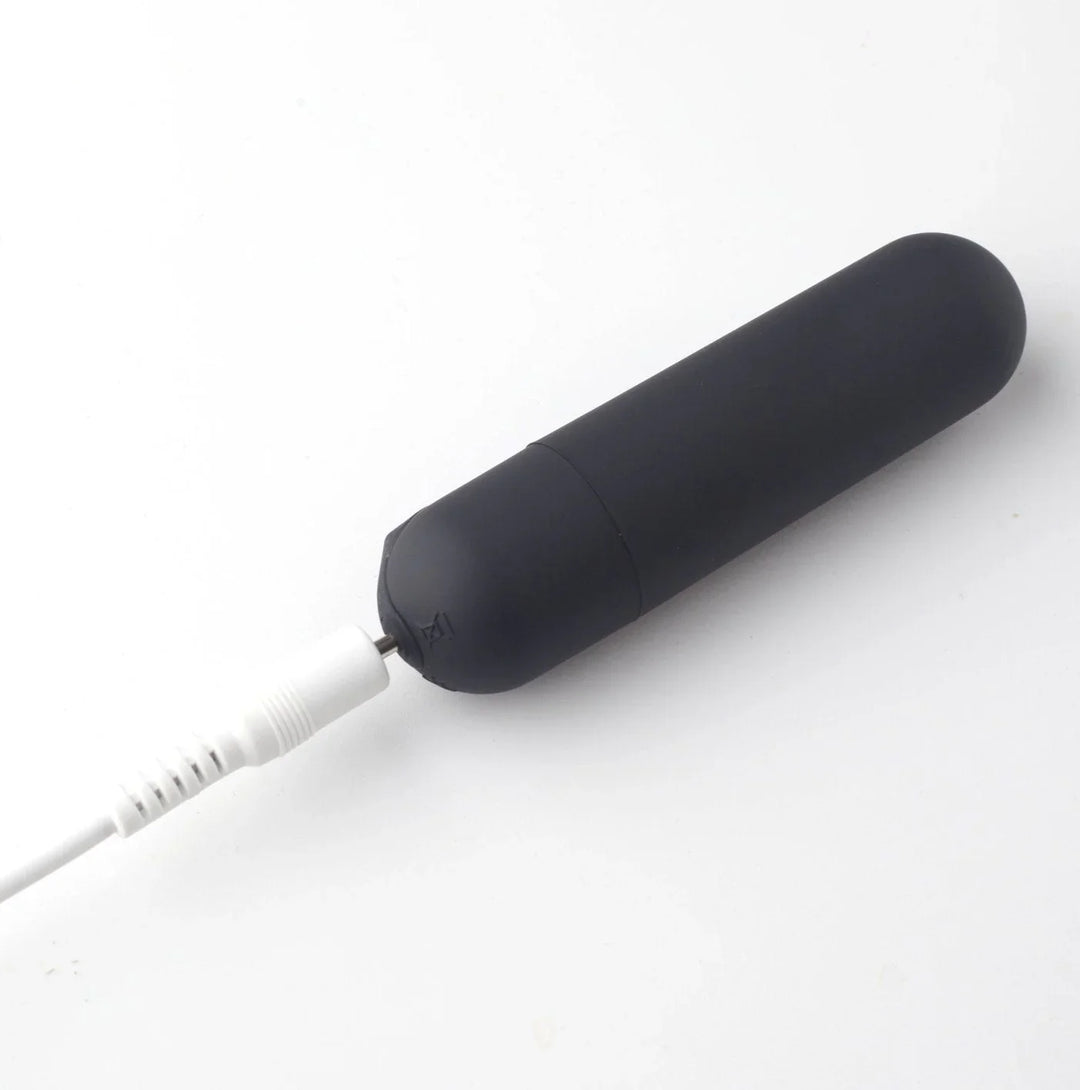 Maia Cody removable bullet in Black on charge, USB cable plugged into the base