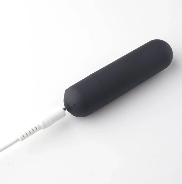 Maia Cody removable bullet in Black on charge, USB cable plugged into the base