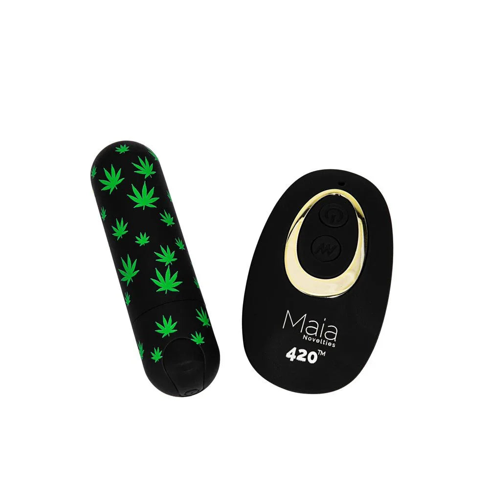 Maia Date Night 420 leaf-print bullet lying beside its black and gold remote