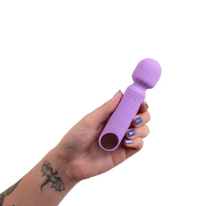 Maia Dolly mini wand in Purple held in a tattooed hand, loop facing the camera