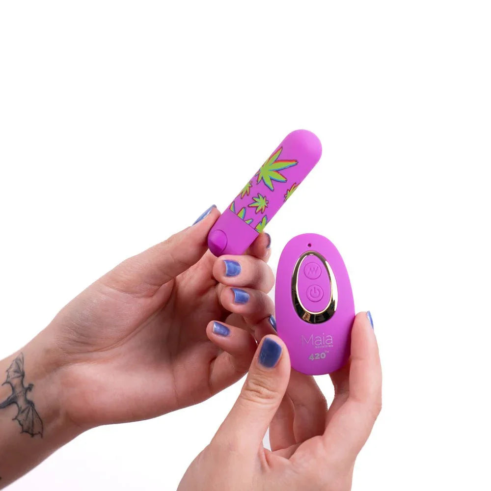 Maia Jessi 420 leaf-print bullet held between fingers with the remote in the palm