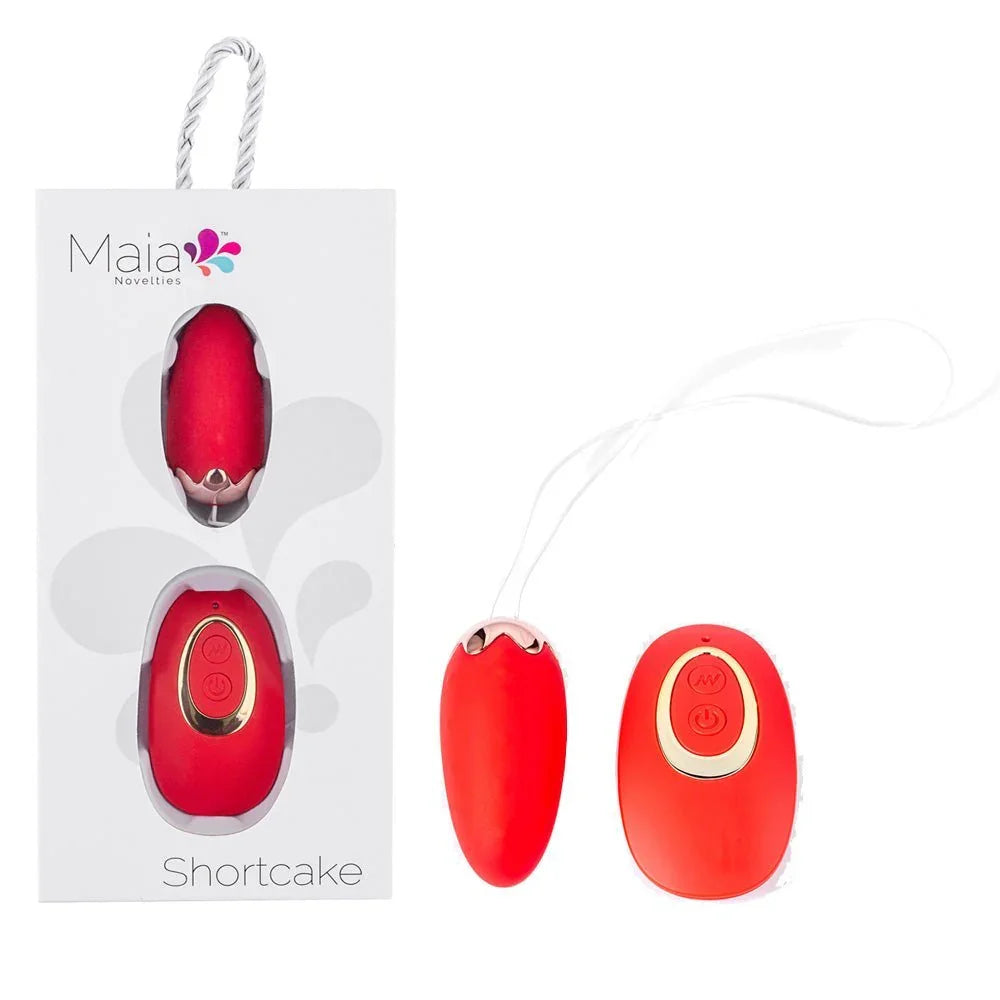 Maia Shortcake vibrating egg in Red with its wireless remote, beside the Maia box