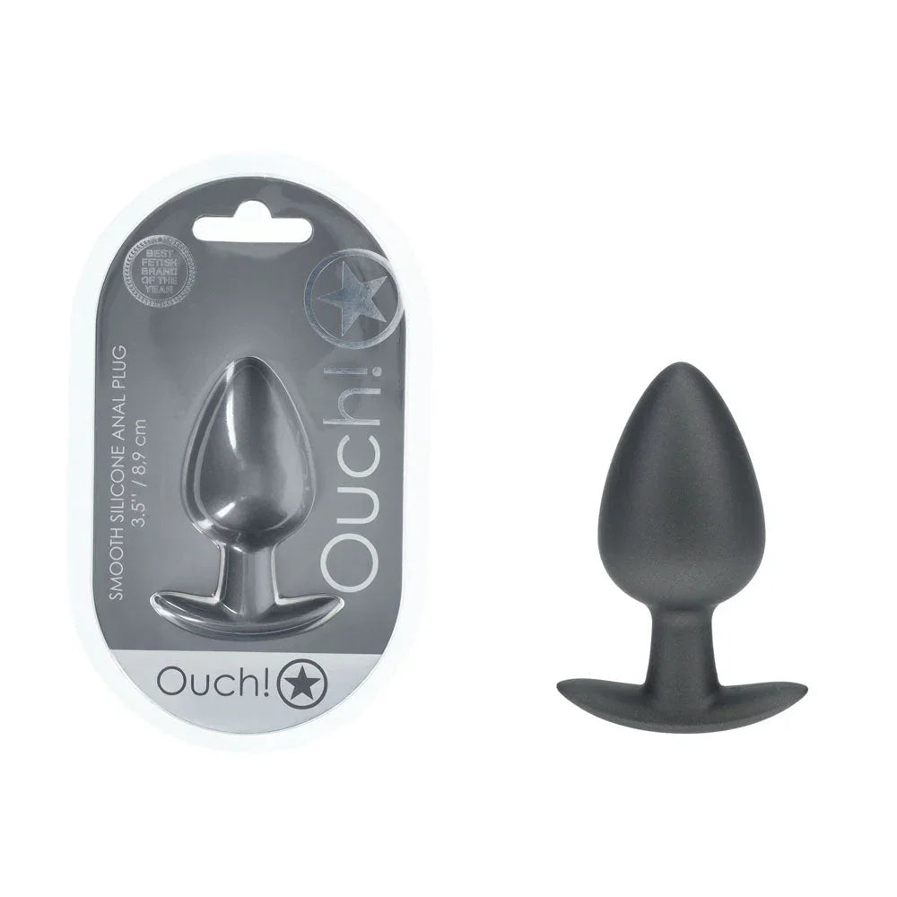 OUCH! Large Metal Anal Plug in Gunmetal, blister pack beside the large tapered plug on white