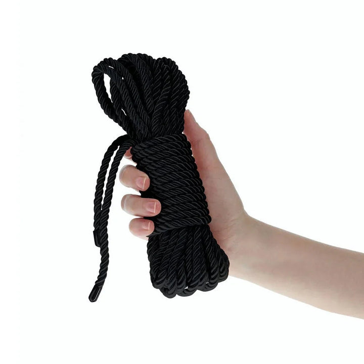 OUCH! Nylon Bondage Rope 10m in Black, the coiled hank held in one hand to show its bulk