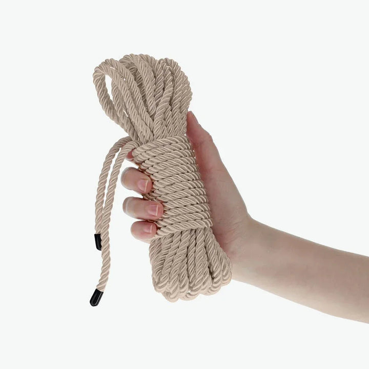 OUCH! Nylon Bondage Rope 10m in Gold, the coiled champagne hank held in one hand