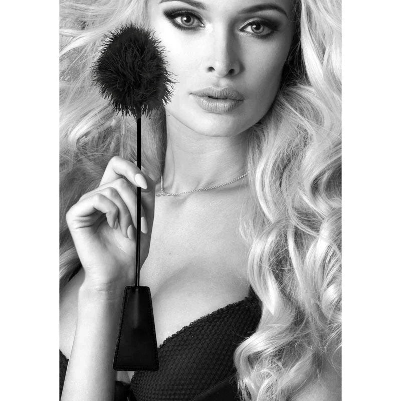 OUCH! Black & White Crop with Feather Tickler in Black, model holding the crop to her face in monochrome