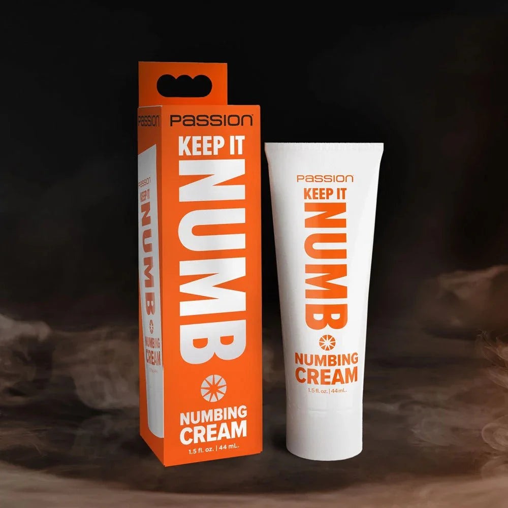Passion Keep It Numb numbing cream, white tube beside its orange carton on a dark backdrop