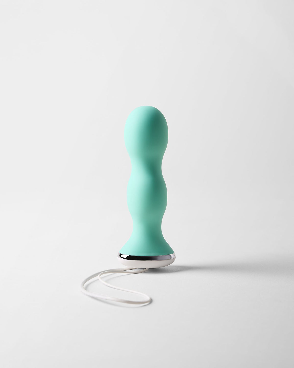 Perifit Care kegel trainer in green, standing upright on a light grey background with its white cord loop