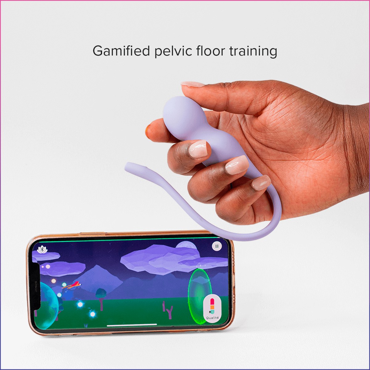 Hand holding a lilac Perifit Care+ above a phone playing a Perifit training game