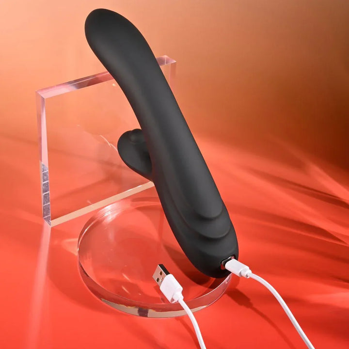 Black Aureus with its white USB charging cable plugged into the base