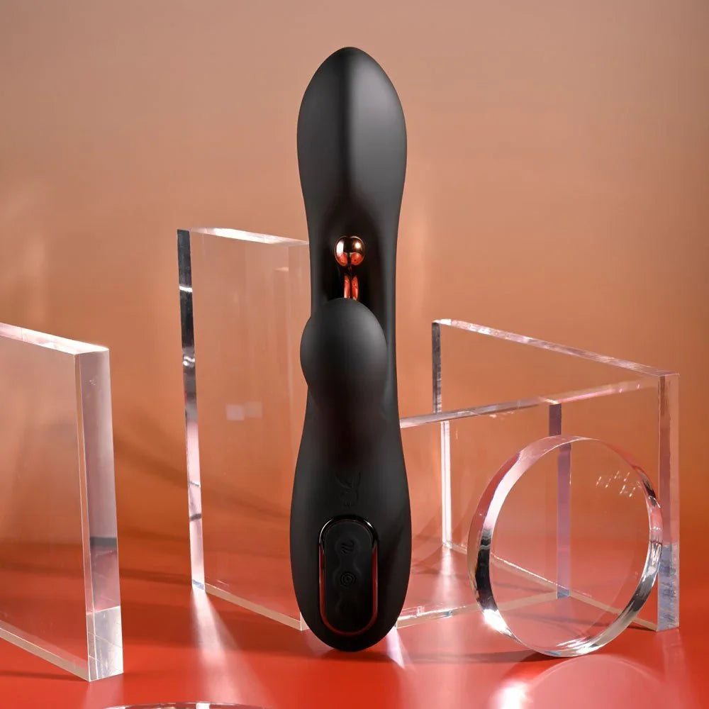 Black Aureus rabbit vibrator standing upright on an orange backdrop, front view