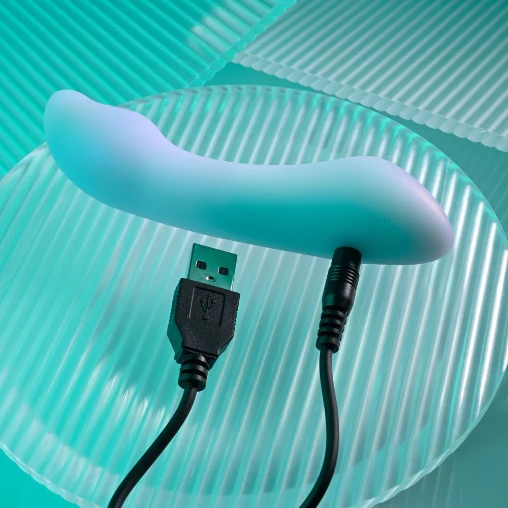 Opal Euphoria mini vibrator with its USB charging cable connected