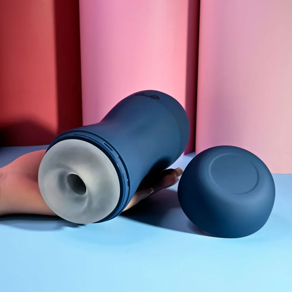 Navy Gusto masturbator on its side with the sleeve opening showing and cap beside