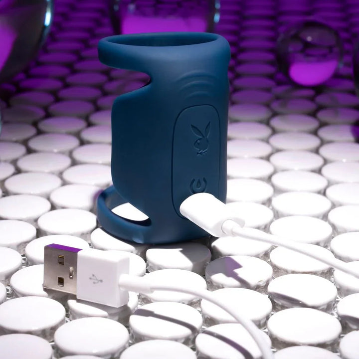 Dark blue Jet Pack with its white USB charging cable plugged into the base