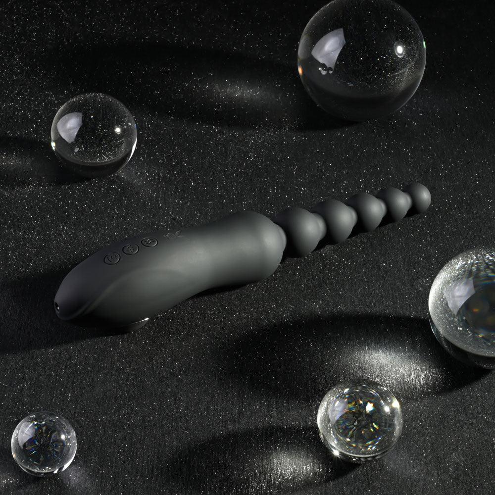 Let It Bead in black angled across black satin, beads catching the light