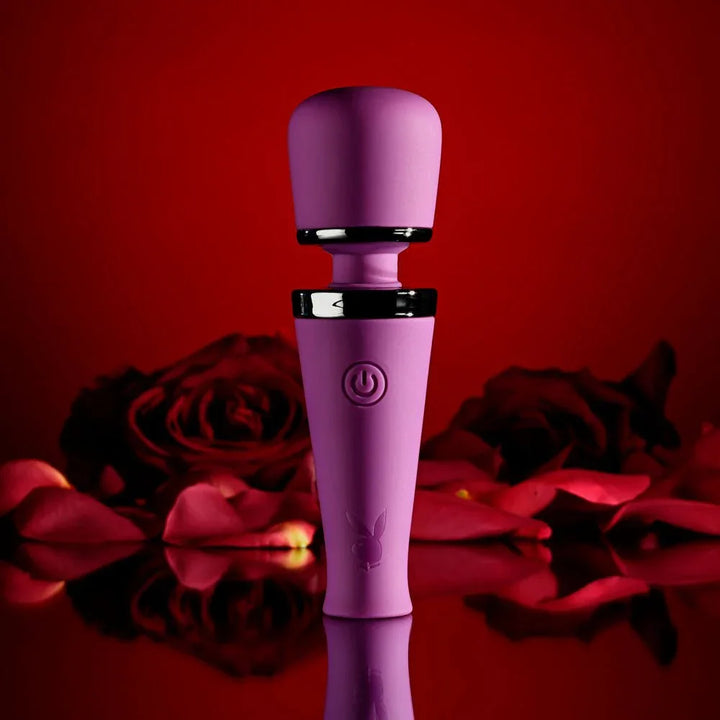 Purple Mic Drop wand standing upright among red roses, chrome collar visible