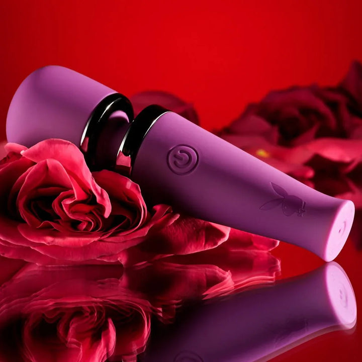 Purple Mic Drop wand lying beside a red rose on a mirrored surface