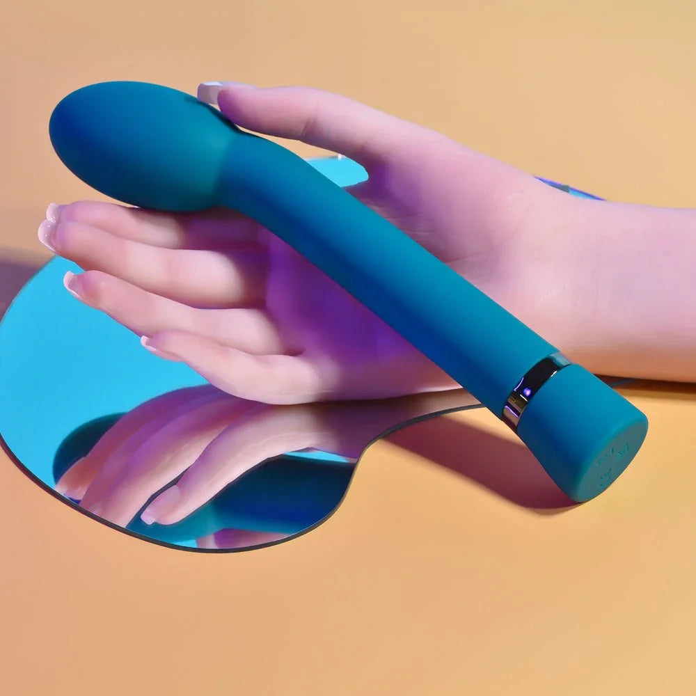Blue On The Spot G-spot vibrator held in a hand, curved tip forward