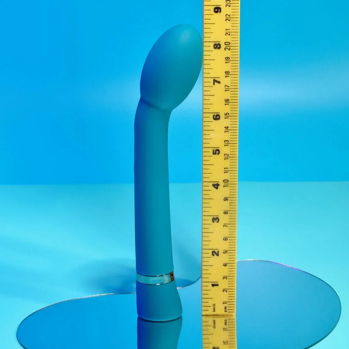 Blue On The Spot G-spot vibrator standing against a ruler at about 8.5 inches