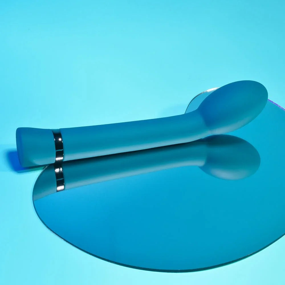 On The Spot in blue lying on a blue mirrored surface, chrome band mid-shaft