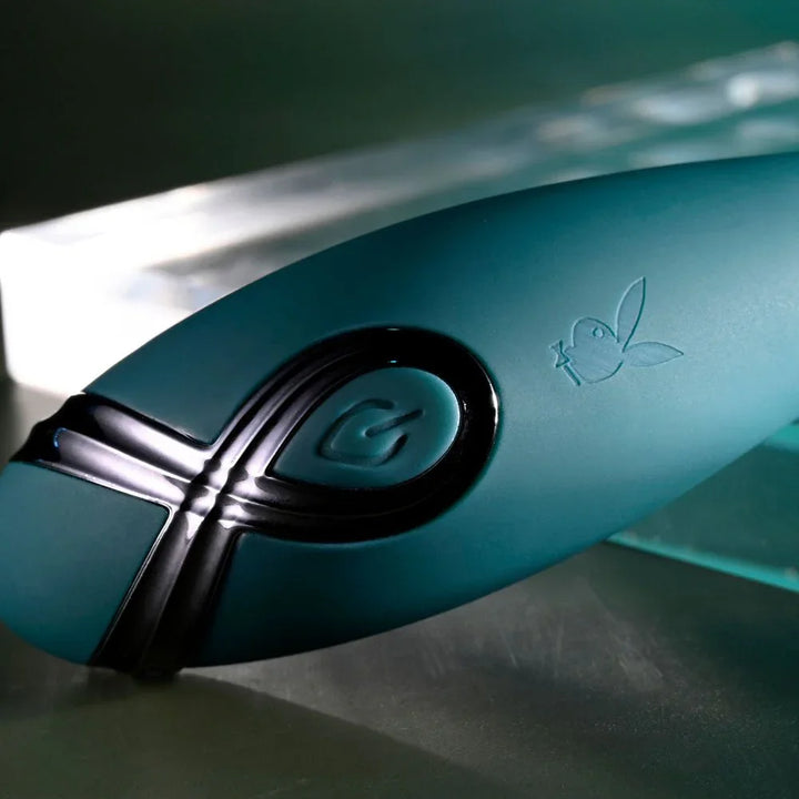 Close-up of the Pinpoint Perfection power button and Playboy bunny on green silicone