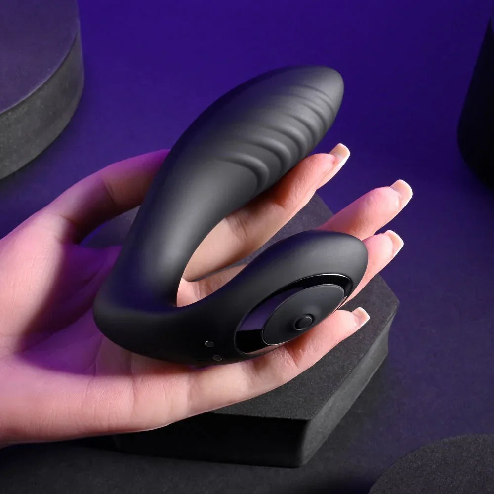 Black Play Time vibrator held in a hand under purple lighting