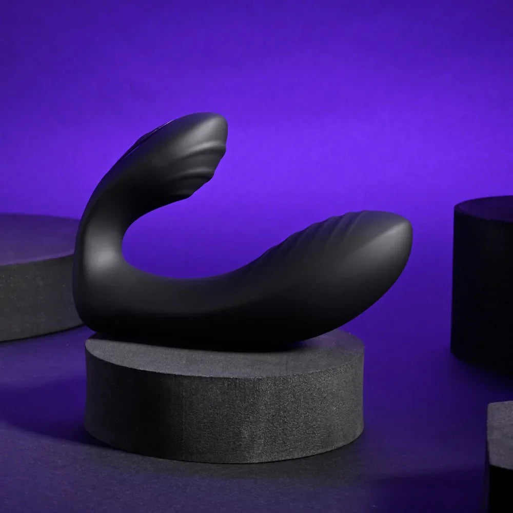 Play Time in black lying on a dark block, showing its curved C shape