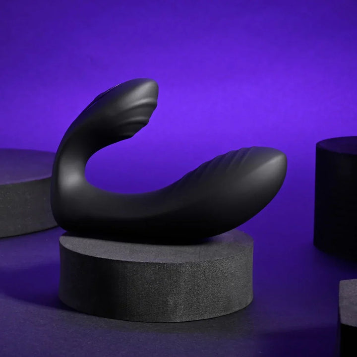 Play Time in black lying on a dark block, showing its curved C shape