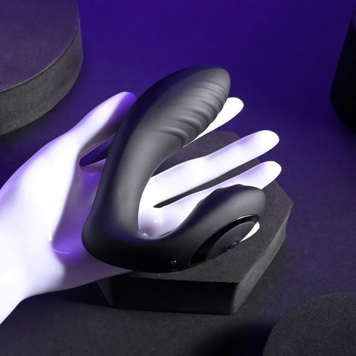 Black Play Time vibrator resting on a white display hand