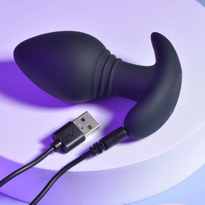 Black Plug & Play butt plug with its USB charging cable connected to the base