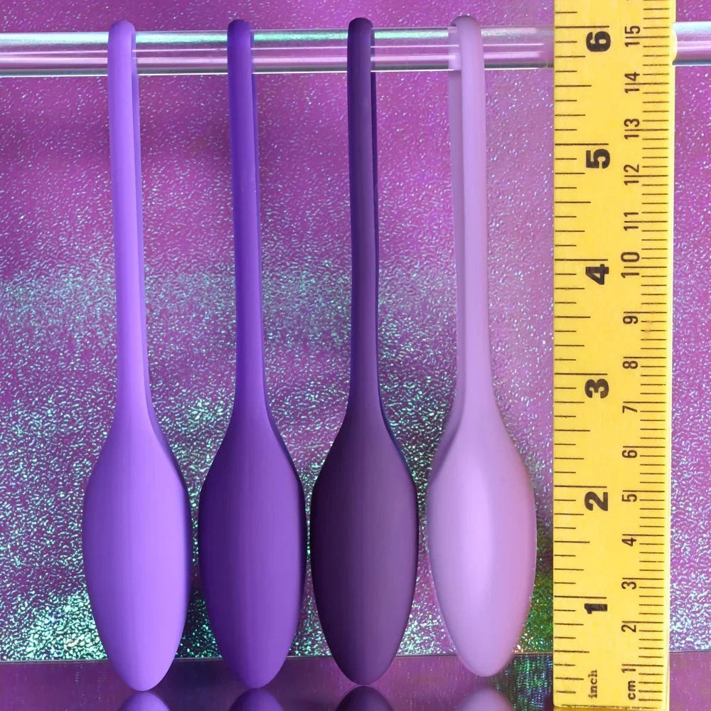 Four Put In Work kegel balls beside a ruler, each ball roughly 1.5 inches long