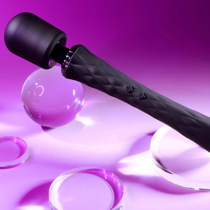Close view of the Royal wand's diamond-textured black handle beside a glass ball