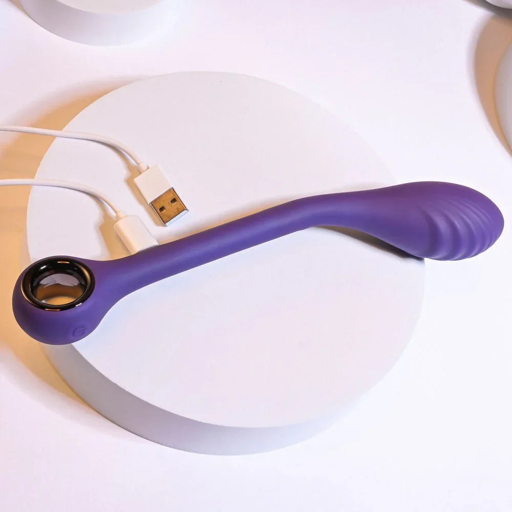 Purple Spot On vibrator on a white disc with its USB charging cable attached