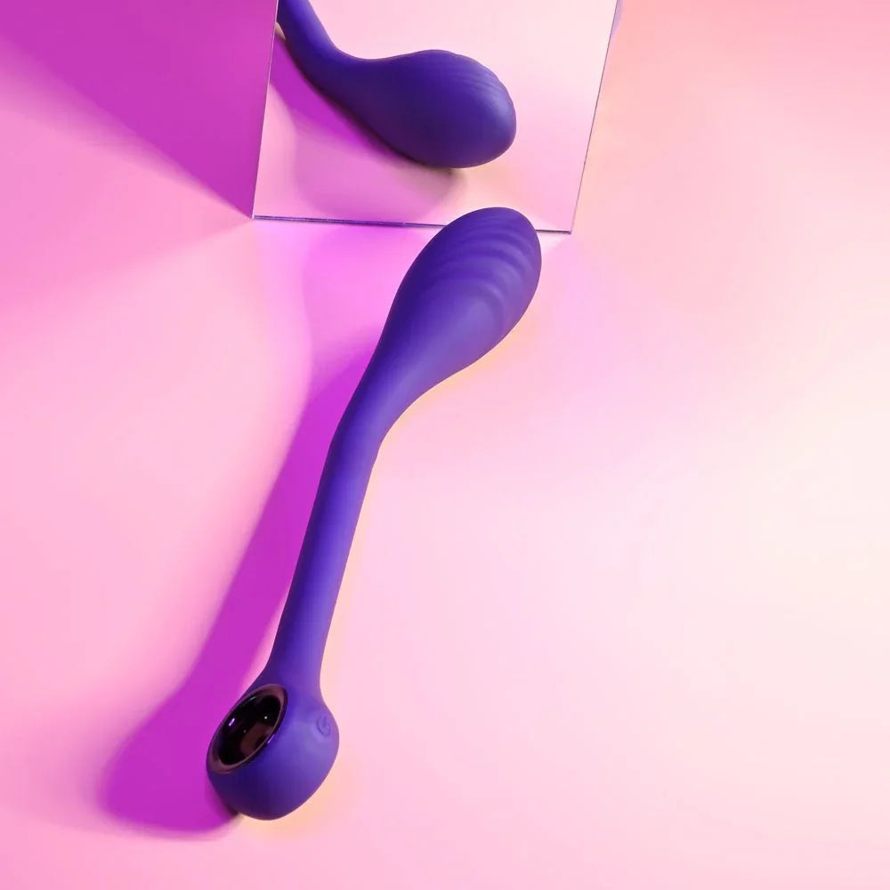 Spot On in purple leaning against a mirror under pink light, curved tip up