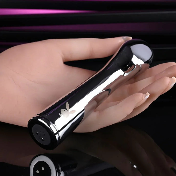 Chrome Swoon vibrator resting on an open hand to show its 14 cm size