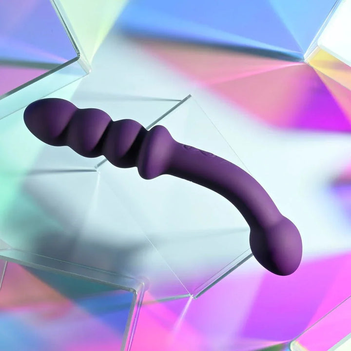 Close-up of The Seeker's graduated beaded end in purple curving over glass