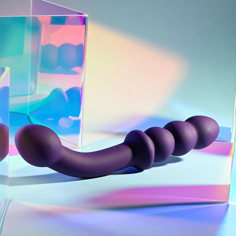 The Seeker in purple resting against an iridescent panel, side profile