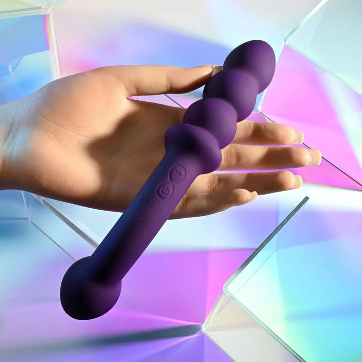 The Seeker double ended vibrator held in a hand, control buttons visible mid-shaft