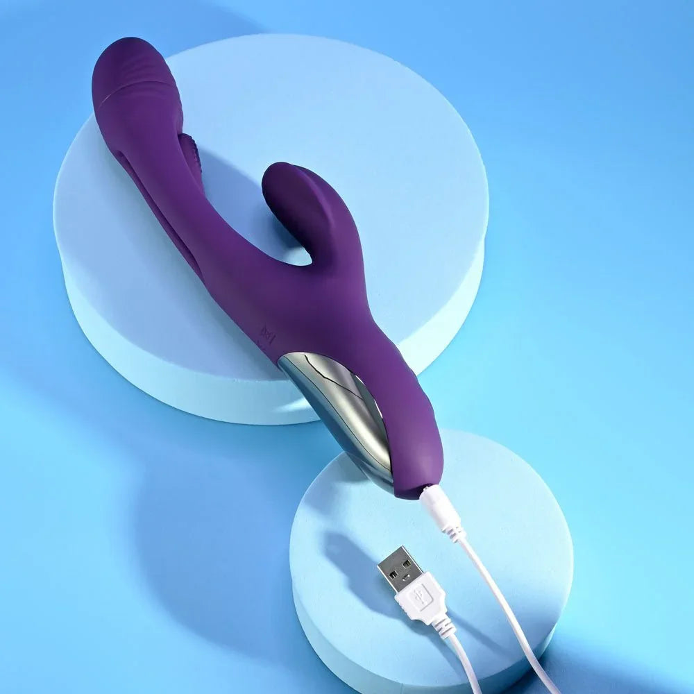 Purple Thrill rabbit vibrator with its USB charging cable plugged into the base