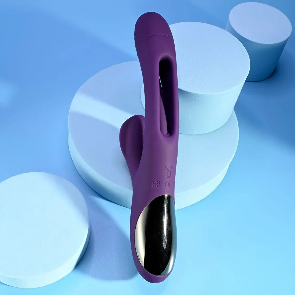 The Thrill in purple leaning on blue podiums, ribbed clitoral arm in view