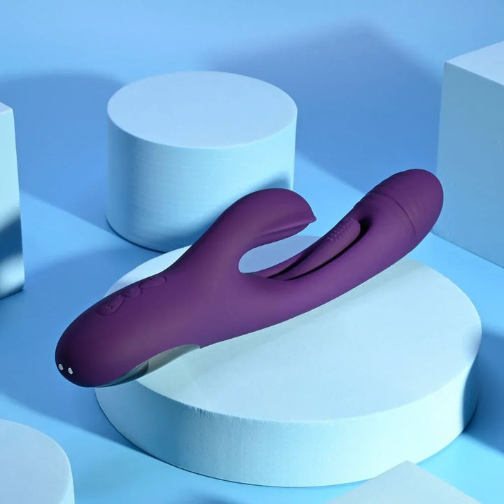 Purple Thrill rabbit vibrator lying across pale blue podiums, clitoral arm forward