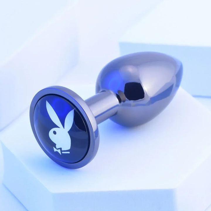 Chrome TUX butt plug angled to show the blue Playboy bunny medallion on its base