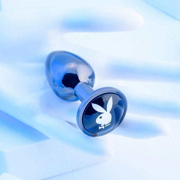 Chrome TUX butt plug lying flat with the blue bunny medallion facing up