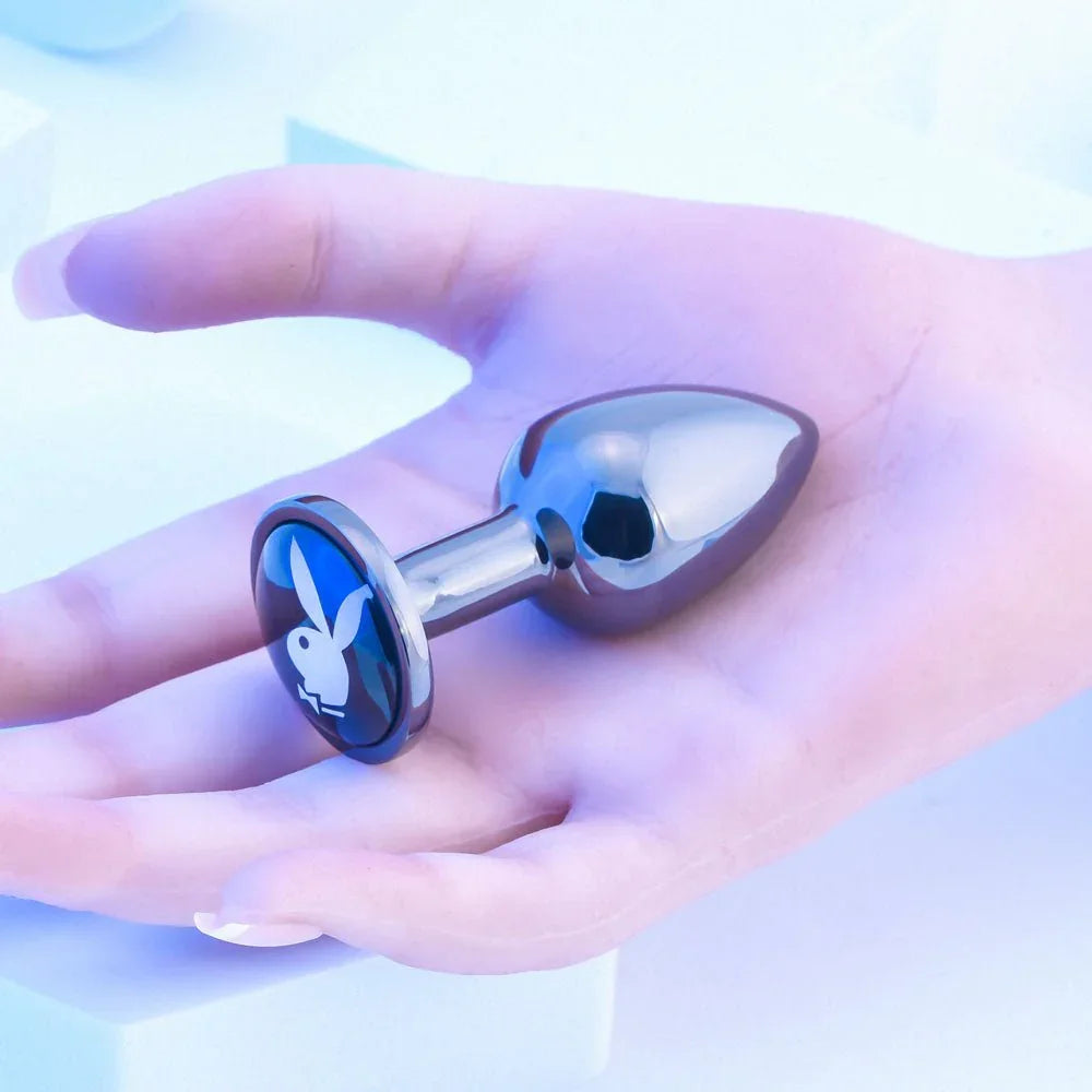 Chrome TUX small butt plug held flat in a hand to show how compact it is